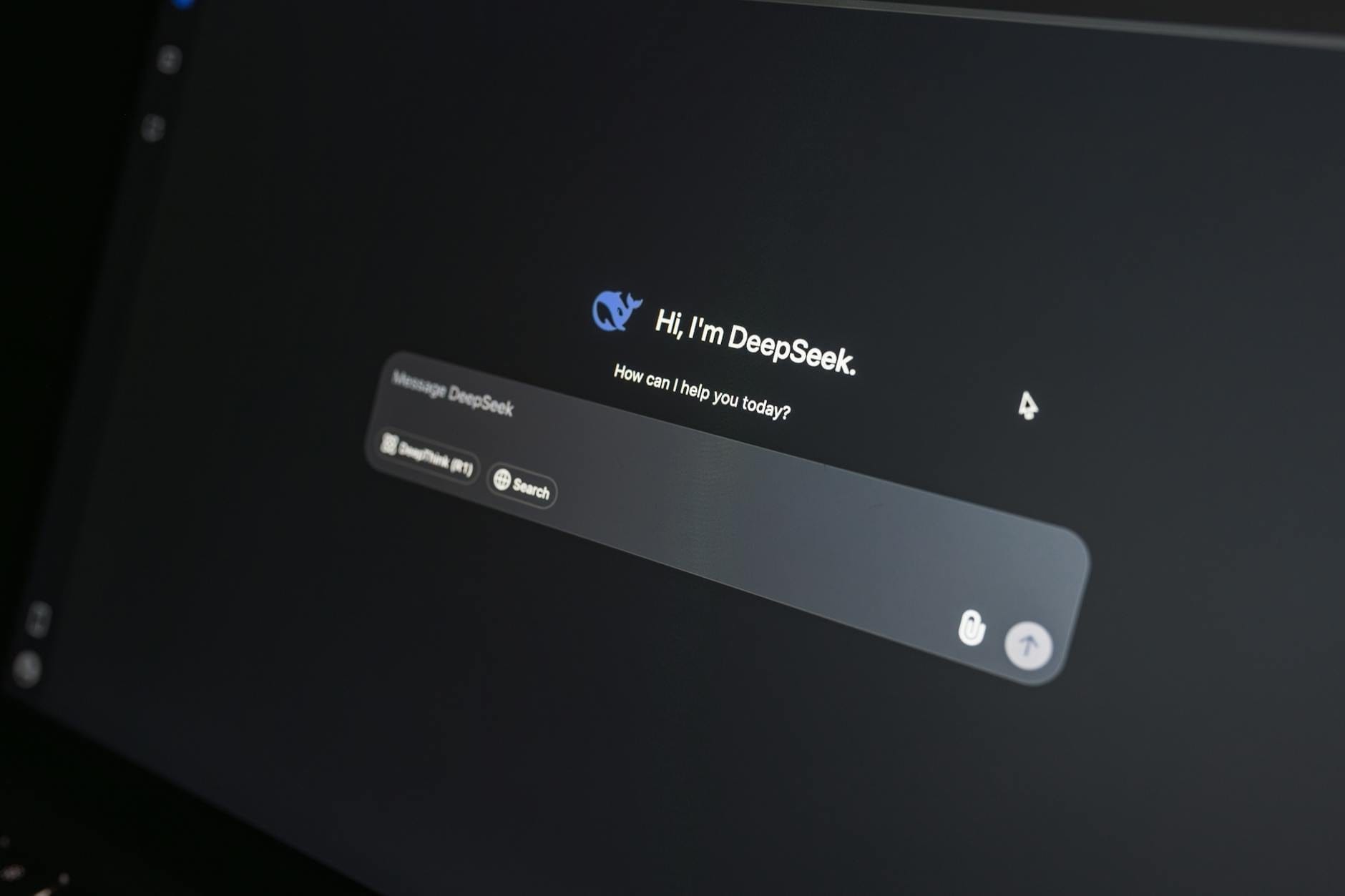 Interfejs czatu DeepSeek AI na ekranie laptopa w ciemnym otoczeniu