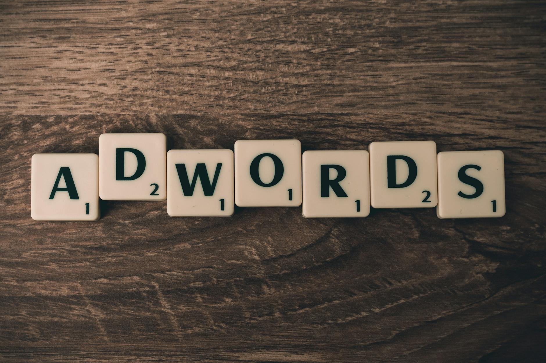 Kafle Scrabble układające się w napis AdWords na drewnianym stole