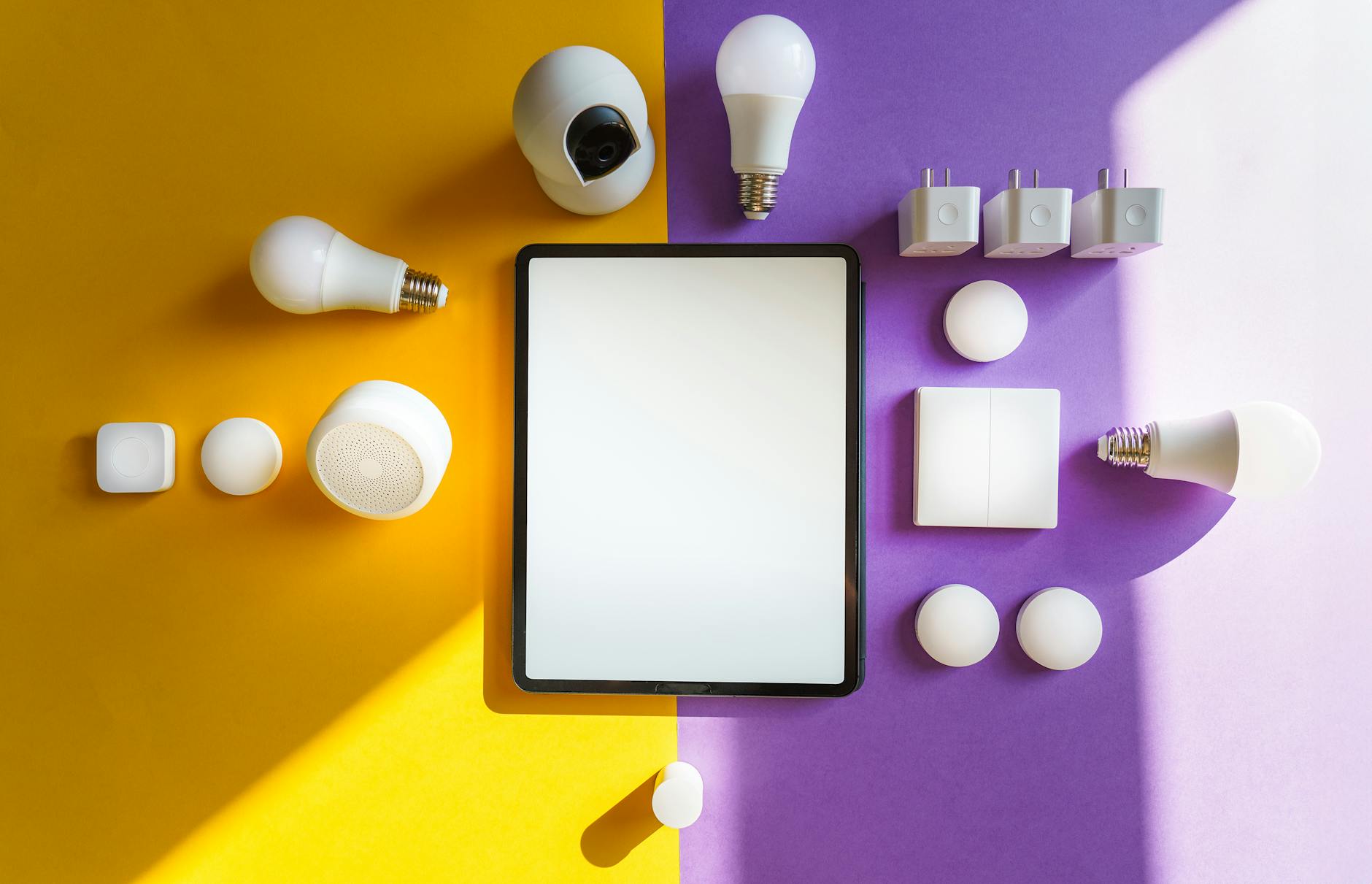 Tablet i urządzenia smart home na żółto‑fioletowym tle