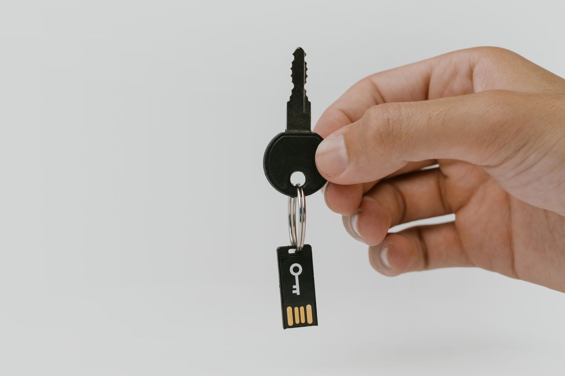 Dłoń trzymająca klucz z pendrive’em symbolizująca ochronę danych