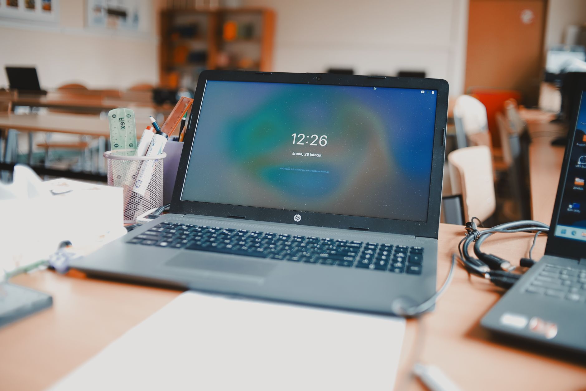 Laptopy na biurkach w nowoczesnej sali szkoleniowej z kursami online
