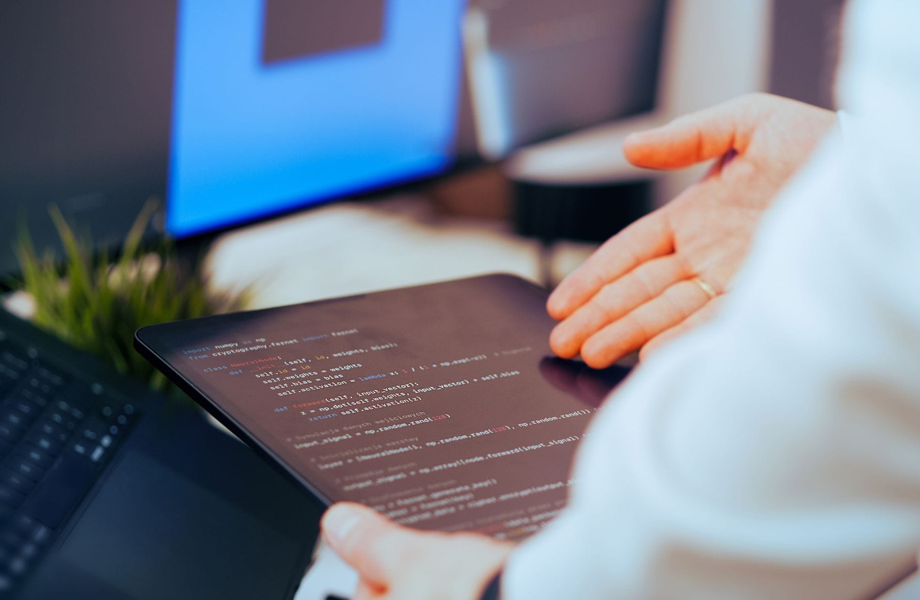 Programista analizuje kod na tablecie w nowoczesnym biurze AI Programista analizuje kod na tablecie w nowoczesnym biurze AI