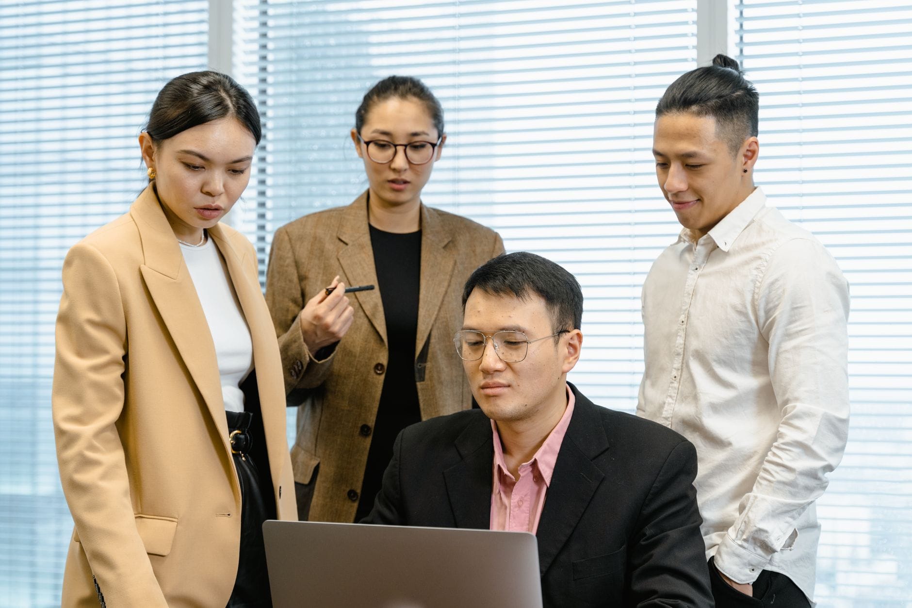 Zespół marketerów B2B omawia kampanię AI przy laptopie w biurze